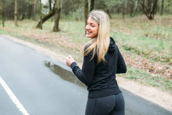 Egy sportos ábra lány részt vesz a park — Stock Fotó