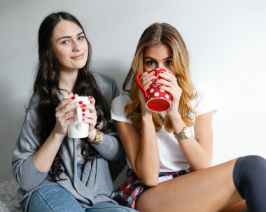 gülüyor ve bardak ve inha ile poz iki genç güzel kız