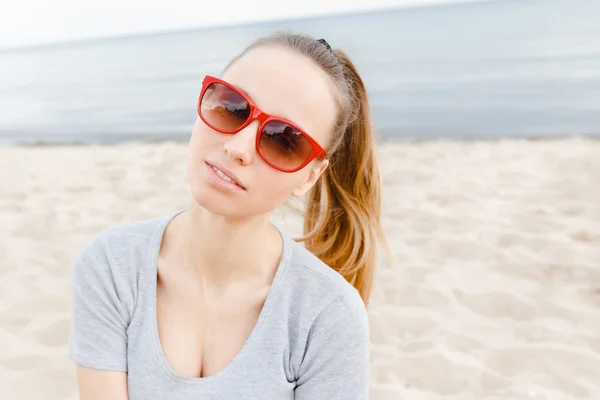 Sports girl on the beach wearing sunglasses — Stock Photo, Image