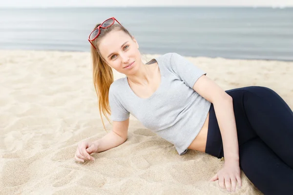 Sport lány a strandon, napszemüveget visel — Stock Fotó