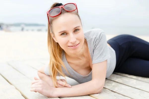 Sports girl on the beach wearing sunglasses — Stock Photo, Image