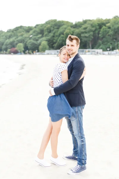 Europese paar ontspannen op het strand van de zee knuffelen elkaar — Stockfoto