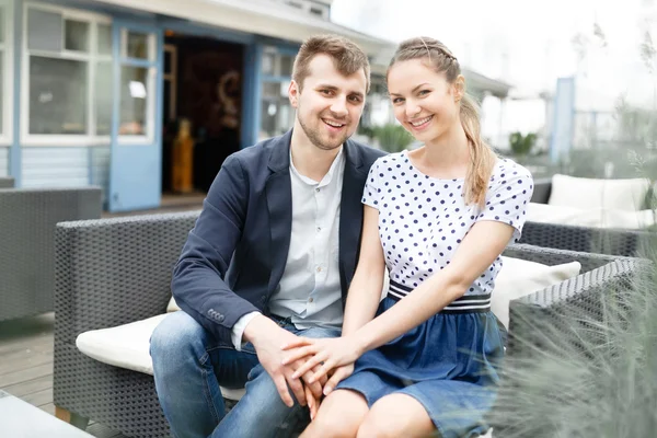 Una joven pareja pasa tiempo en el sofá en la cafetería al aire libre —  Fotos de Stock