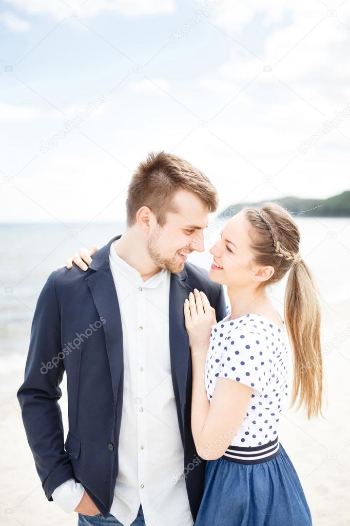 European couple relaxing on the sea beach hugging each other