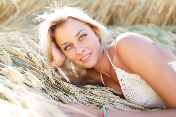 Attractive blonde walking and posing on a rye field in summer da — Stock Photo, Image