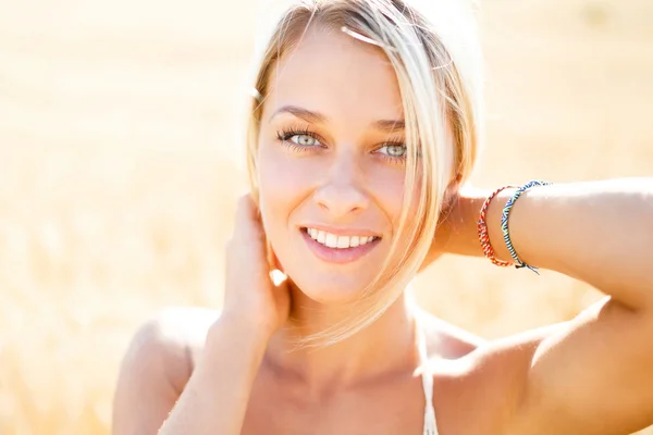 Aantrekkelijke blonde wandelen en poseren op een veld met rogge in zomer da — Stockfoto