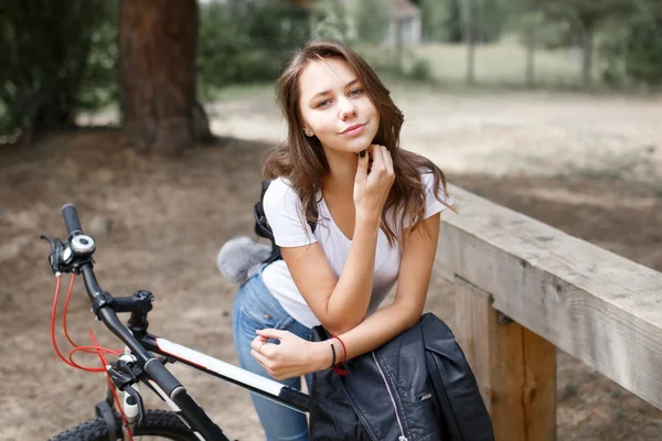 The girl on the bike ride in the woods on a mountain bike. — Stock Photo, Image