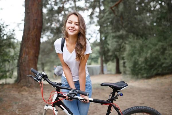 The girl on the bike ride in the woods on a mountain bike. — 图库照片