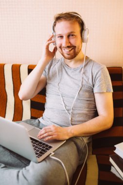 Bir dizüstü bilgisayarda müzik genç bir adam