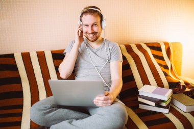 Bir dizüstü bilgisayarda müzik genç bir adam