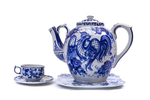 Фарфоровый чайник, чашка и блюдце в народном стиле окрашены синий на белом фоне Лицензионные Стоковые Изображения