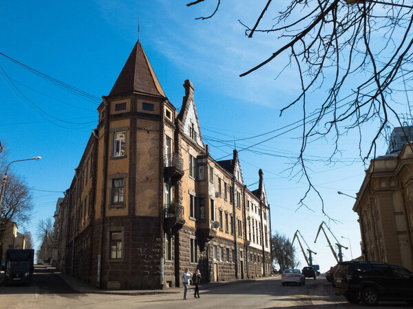 Old beautiful building Iron House or Witch House in the historic center. House with stone and spiers. There is a port with cranes nearby.
