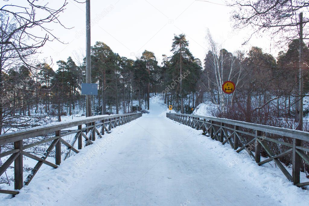Winter view of the bridge and river at the Langinkoski Imperial Fisherman's House. Kotka, Finland. Pedestrian bridge to the park and mountains.