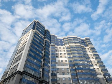 Gökyüzüne karşı modern bir binanın parçası. Yüksek katlı apartmanlar. Beyaz ve mavi.