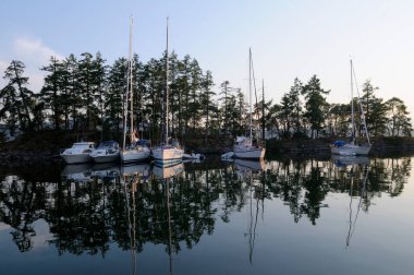 Boats reflected in the still water, Princess Bay, Wallace Island, Gulf Islands, British Columbia, Canada
