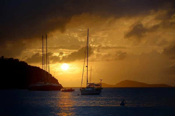 Hazine Noktası 'nın önünde dramatik bir gün batımı olan yelkenliler, The Bight, Norman Adası, Britanya Virgin Adaları