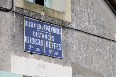 Bahar ağaçları ve yaprakların arasından süzülen su yolu, Fransa, Loire Kanalı.