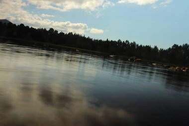 Güneş altında Morlich Gölü 'nün etrafında oynuyorlar.