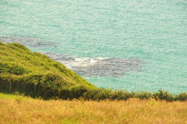 Kayaların üzerindeki bulutlar ve Cornish kıyılarındaki su