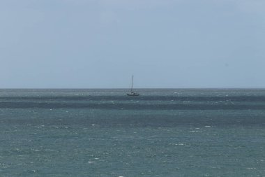 Cornish sahilinde dalgalı dalgalarda yüzen yelkenli.