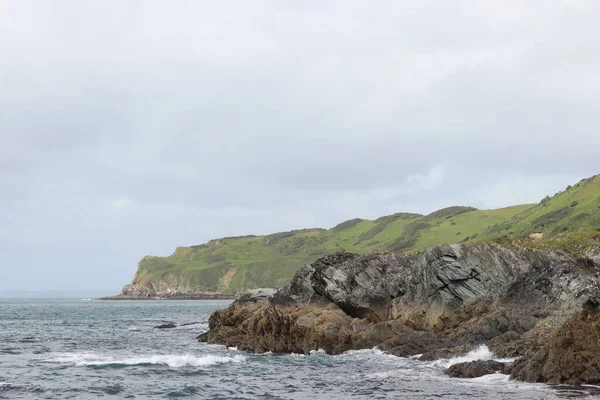 コーニッシュ海岸の岩や水の上の雲 — ストック写真