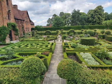 A majestic view of Hatfield House in Hertfordshire towering over manicured lawns and gardens clipart