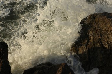Atlantik dalgaları Carlyon körfezine doğru süpürüyor kumsaldaki kumu temizliyor ve İngiltere 'nin güney kıyısı ve Cornwall ilçesi açıklarındaki fırtınayı takiben kayaların üzerine çarpıyor.