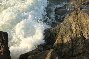 Atlantik dalgaları Carlyon körfezine doğru süpürüyor kumsaldaki kumu temizliyor ve İngiltere 'nin güney kıyısı ve Cornwall ilçesi açıklarındaki fırtınayı takiben kayaların üzerine çarpıyor.
