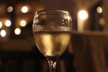 Geceleri şarap kadehi yakındaki lambalardan gelen ışığı dağıtıyor.