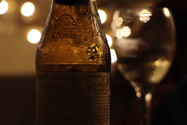 Garrafa Cerveja Noite Espalhando Luz Lâmpadas Próximas — Fotografia de Stock
