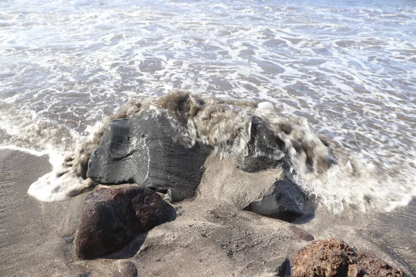 Dalgalar Tener Bir Kumsalda Siyah Kum Kayaların Üzerine Düşüyor — Stok fotoğraf