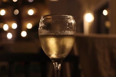 Geceleri şarap kadehi yakındaki lambalardan gelen ışığı dağıtıyor.