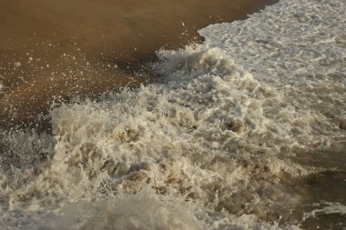Dalgalar kayaların üzerinden geçip St. Austell, Cornwall, İngiltere 'nin dışındaki Carlyon Körfezi sahiline çarpıyor. Atlantik Okyanusu' ndaki fırtınanın ardından.
