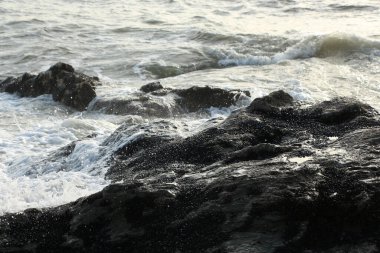 Dalgalar kayaların üzerinden geçip St. Austell, Cornwall, İngiltere 'nin dışındaki Carlyon Körfezi sahiline çarpıyor. Atlantik Okyanusu' ndaki fırtınanın ardından.