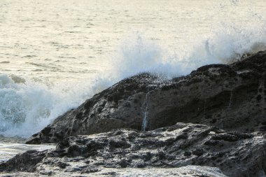 Dalgalar kayaların üzerinden geçip St. Austell, Cornwall, İngiltere 'nin dışındaki Carlyon Körfezi sahiline çarpıyor. Atlantik Okyanusu' ndaki fırtınanın ardından.