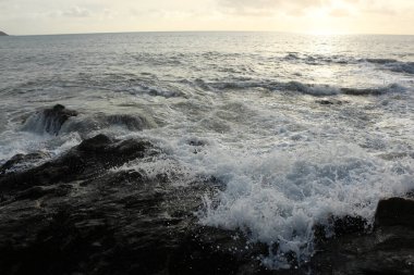 Dalgalar kayaların üzerinden geçip St. Austell, Cornwall, İngiltere 'nin dışındaki Carlyon Körfezi sahiline çarpıyor. Atlantik Okyanusu' ndaki fırtınanın ardından.