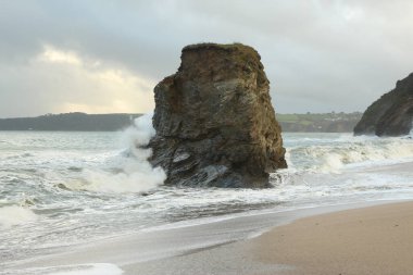 Carlyon körfezi sahilindeki kayaların ıssız bir sütunu Atlantik Okyanusu açıklarında bir yerlerde meydana gelen ve İngiltere 'nin güneybatısındaki Cornwall sahiline çarpan güçlü dalgalar tarafından dövüldü.
