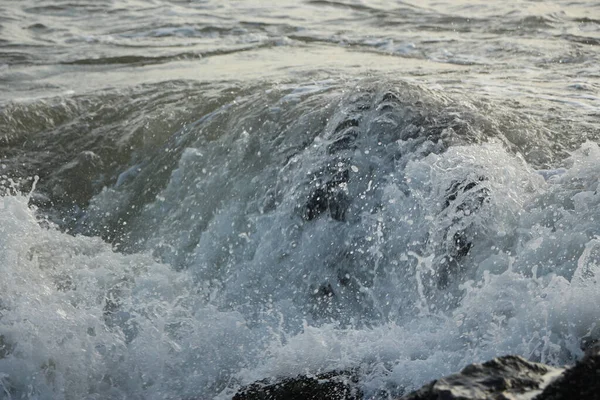 波は岩を越えて 大西洋の海に遠くの嵐の後 イングランドのコーンウォール州セントオーステルの外のカリヨン湾のビーチに衝突します — ストック写真