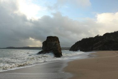 Carlyon körfezi sahilindeki kayaların ıssız bir sütunu Atlantik Okyanusu açıklarında bir yerlerde meydana gelen ve İngiltere 'nin güneybatısındaki Cornwall sahiline çarpan güçlü dalgalar tarafından dövüldü.