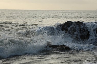 Dalgalar kayaların üzerinden geçip St. Austell, Cornwall, İngiltere 'nin dışındaki Carlyon Körfezi sahiline çarpıyor. Atlantik Okyanusu' ndaki fırtınanın ardından.