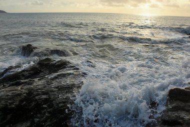 Dalgalar kayaların üzerinden geçip St. Austell, Cornwall, İngiltere 'nin dışındaki Carlyon Körfezi sahiline çarpıyor. Atlantik Okyanusu' ndaki fırtınanın ardından.