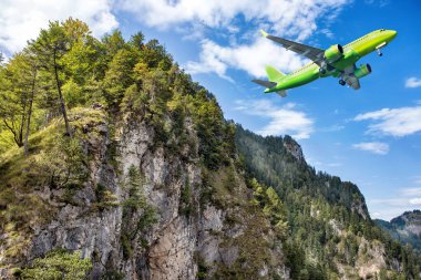 Güzel yüksek dağların üzerinde uçan büyük sarı bir jet..