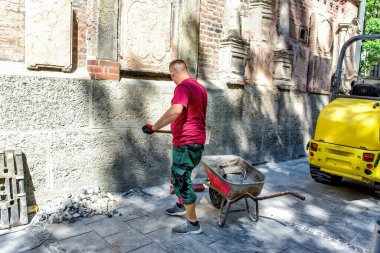 Eski bir katedralin kaldırımlarını tamir eden bir işçi...