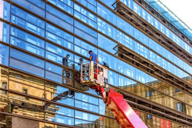 Münih, Almanya - 12 Eylül 2018: İnşaat işçileri bir gökdelenin camlarını temizliyor.