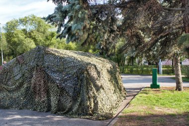 Yazın açık havada bir parkta kamuflaj askeri çadırı..