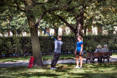 Münih, Almanya - 12 Eylül 2018: Koçu olan hamile bir kadın parkta egzersiz yapıyor.