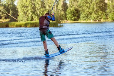 Yaz günü can yeleğiyle gölde uyanan bir adam. Yumuşak odaklanma. Eylem bulanıklığı. 