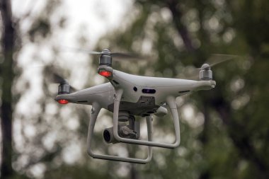 Yerden kalkan beyaz bir dron kuadkopteri. Yumuşak odaklanma. Hareket bulanıklığı.