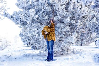 Karlı bir günde Sibirya ormanında dev bir rakun kedisini tutan bir kadın. Kavram: Kış.