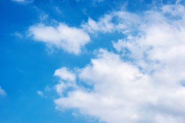 Mavi gökyüzünün arka planında kabarık beyaz bulutlar.